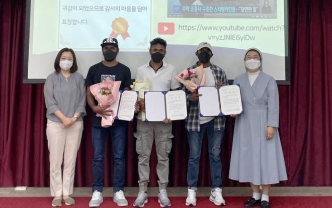 2022년 9월 4일 조종사를 구한 공로로 화성시 외국인복지센터장 표창장을 받은 루완 씨(가운데)와 동료들이 사진을 찍고 있다. 뉴시스(화성시 외국인복지센터 제공)